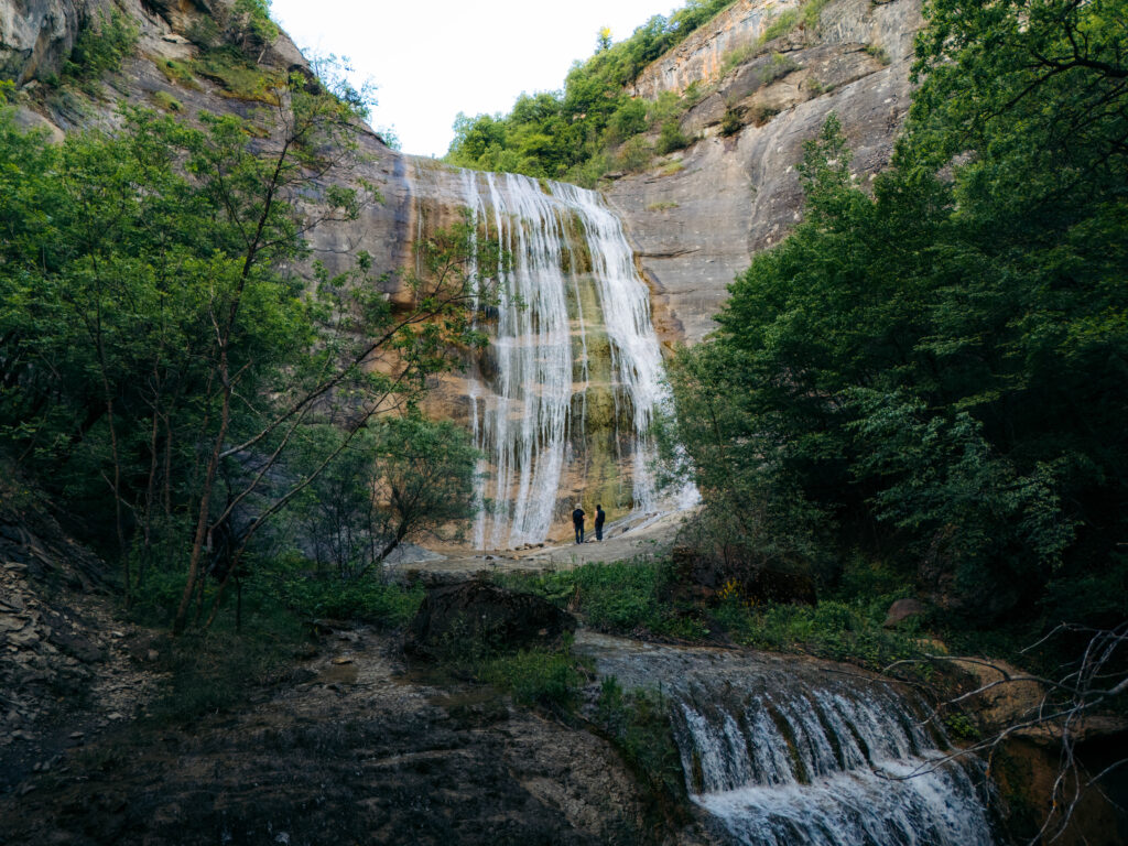 Waterfall cascading over a rocky cliff in a forest near Kastoria, Greece.