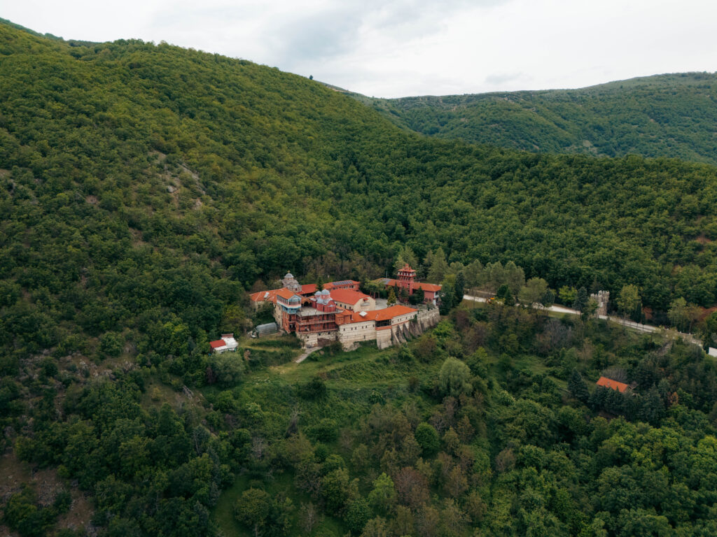 Aerial view of a monastery surrounded by dense forest near Kastoria, Greece.